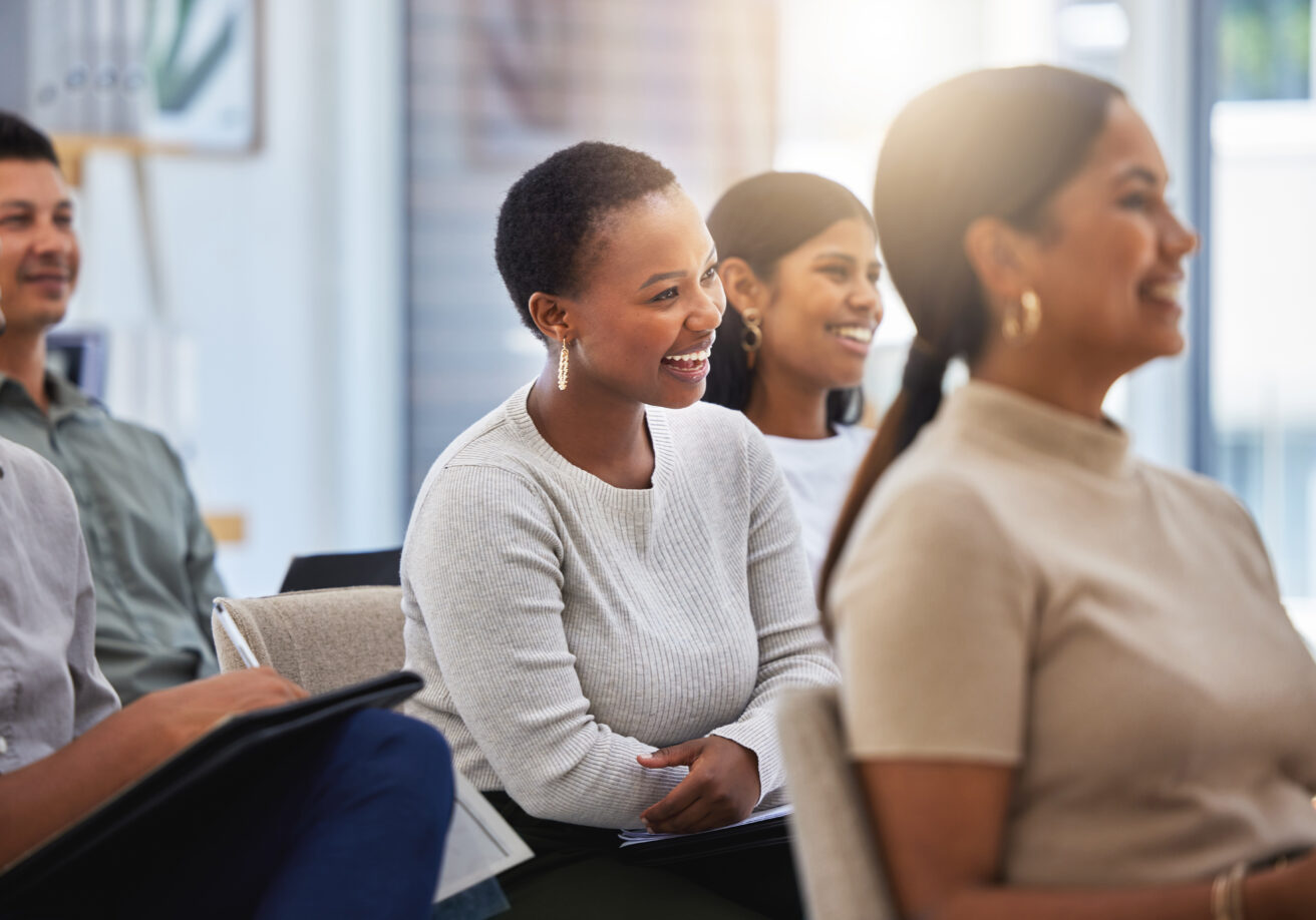 Shot of a group of employees laughing during a meeting at work in a modern office